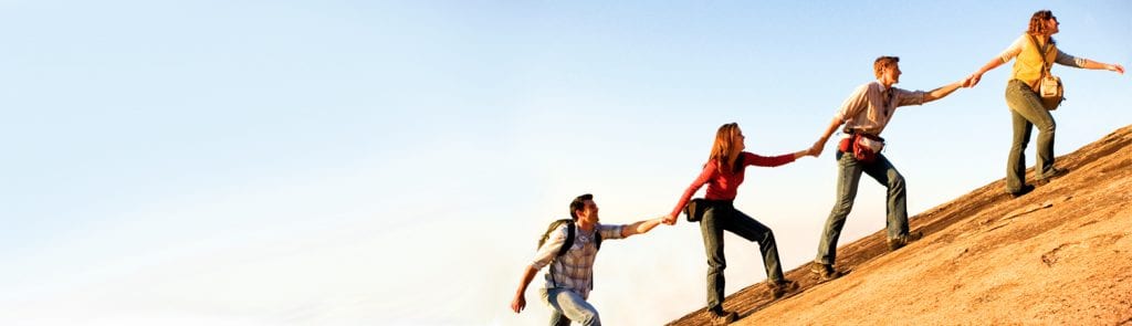 group helping each other climb
