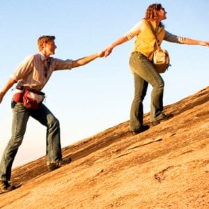 group helping each other climb